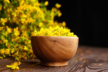 Wooden bowl with Hypericum perforatum or St Johns wort flowers buds