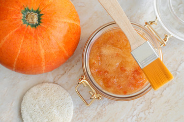Pumpkin sugar scrub in a glass jar. Homemade beauty treatment and spa recipe. Top view, copy space.