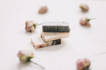 Soap bars with dry roses on white background. Handmade floral soap with rose buds. Natural cosmetics. flat lay, top view