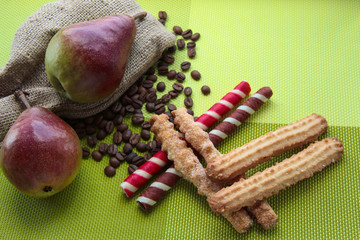 Sweet cookies on a green background with pears, coffee beans and burlap.