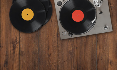 old vintage turntable with vinyl records on a wooden table. Top view