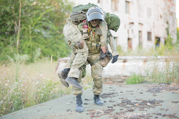 Military partner carries his wounded partner from shelling