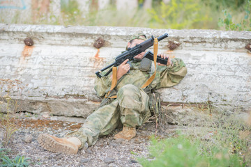 Fototapeta premium Airsoft player reloads his weapon during a firefight