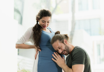 Fototapeta premium Beard man take care his pregnant wife and listen to the baby.