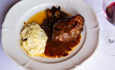 Delicious stewed in oven lamb meat with gravy served with fried mushrooms and mashed potato