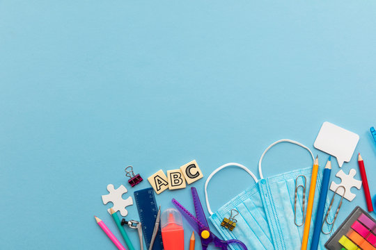 Back to school concept. School supplies with a medical face masks