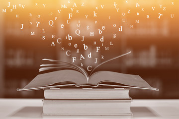 Open book on the table and English alphabet Floating above the book in the library and blur...