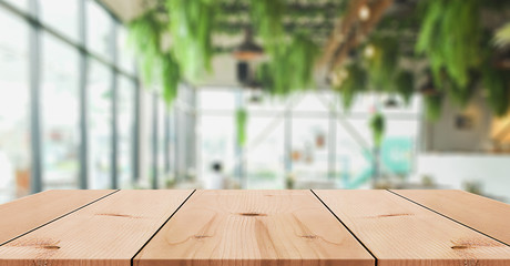 Empty wooden table top with lights bokeh on blur restaurant background	
