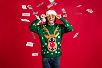 Portrait of his he nice attractive glad cheerful cheery guy wear Santa look throwing usd 100 bank...