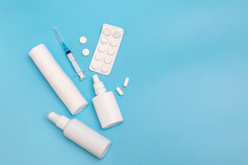Nasal spray, pills, syringe, bandage injection on a blue background. Medicine concept.