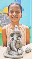 Pune, India, 2 September 2018. Children classes for Ganesh/Ganpati idol making. Eco friendly and home made Ganesh/Ganpati idol/murti. Happy girl holding Ganpati Idol made with mud.