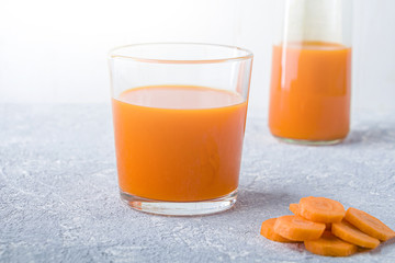 Nutritious detox carrot juice in glass and leaves of parsley. Alkaline diet concept. Organic vegetarian drink. Healthy eating. Still life, copy space for text