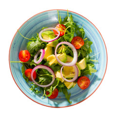 Light salad with avocado, arugula, tomatoes cherry and onion. Isolated over white background