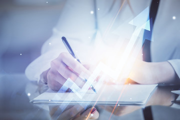 Blue arrow over woman's hands taking notes background. Concept of success. Double exposure