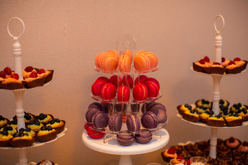 orange, red and purple macaroons on stander