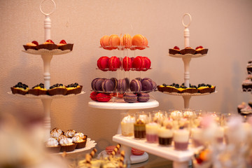 orange, red and purple macaroons on stander