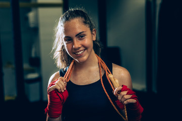 woman posing with jumping rope at the gym
