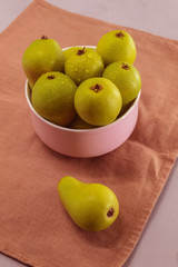 Fresh fruit is in the plate. These are little green pears from the garden