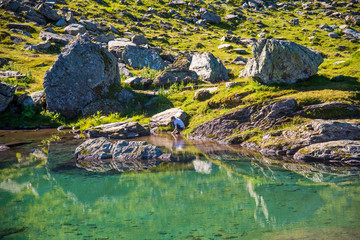 transparent turquoise lake reflecting the landscape in the alps