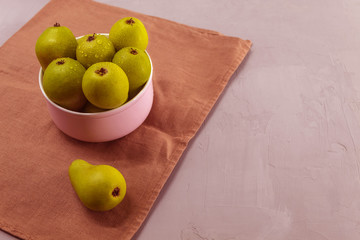 Fresh wild pears in a purple plate on a kitchen towel