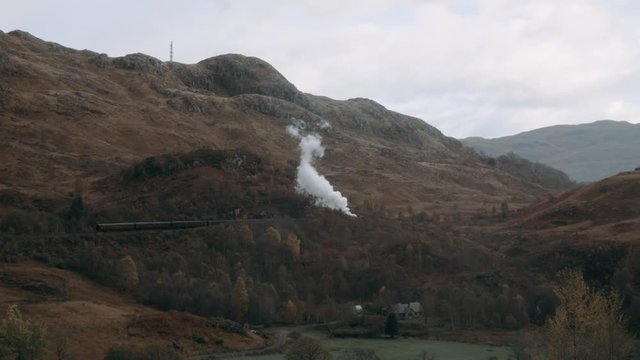 
Jacobite steam train passing the Glenfinnan Viaduct with the mountains in the background in Scotland. Train used in the Harry Potter movie.