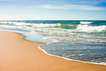 The concept of travel and rest at the seaside, sea waves on the background of the shoreline and sunset