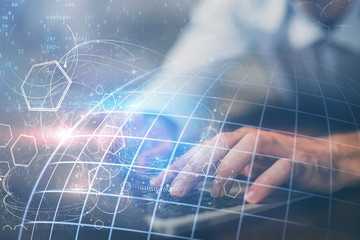 Double exposure of world map hologram with man working on computer on background. Concept of worldwideweb.