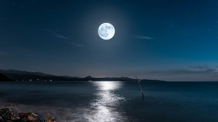 Super moon over the mediterranean sea with mountains in background