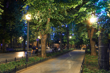 night view of Primorsky boulevard in Odessa city, Ukraine. Beautiful city Park and street illumination, walking people
