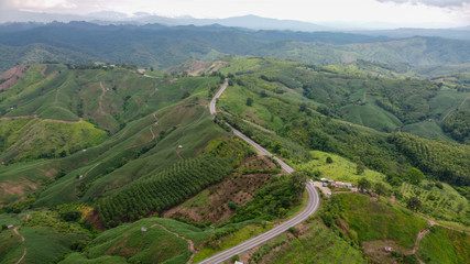 Fototapeta na wymiar Nan, Thailand. Aerial view of Beautiful sky road over top of mountains with green jungle. Road trip on curve road in mountain.