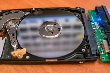 hard disk is lying on table, blinking and spinning disk. Work of hacked