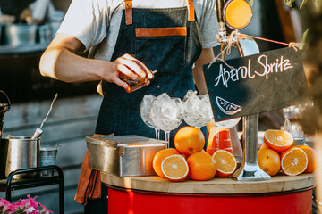 bartender on the open terrace of the restaurant preparing aperol ice