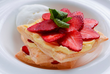 Cake of puff pastry with strawberry. Tasty delicious sweet Italian dessert with strawberry, cream served in white plate