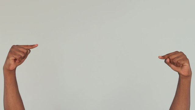 Cropped close up of african man guy male hand arm pointing on workspace thumbs up gesture isolated on grey gray color background in studio. Copy space place for text Advertising area workspace mock up