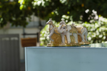 Glass spirit house with marble horses and elephant in Bangkok, Thailand