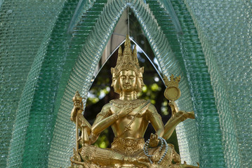 Spirit house in glass with a statue of Phra Phrom, representation of Brahma, the Hindu god of creation in Bangkok, Thailand