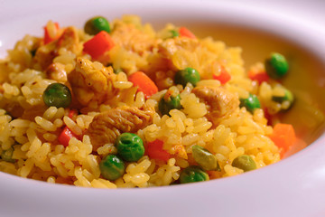 Plain vegetable rice and healthy green vegetables served in a white plate over red plaid background tablecloth.