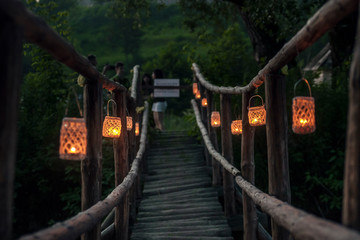 Drewniany mostek oświetlony lampionami - obrazy, fototapety, plakaty