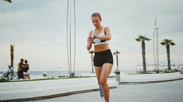 Disabled runner checking her activity status on smartwatch during workout