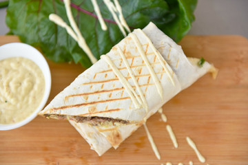 kebab meat with vegetables on a wheat tortilla