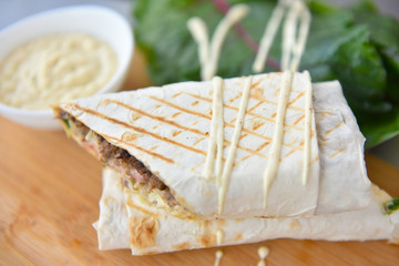 kebab meat with vegetables on a wheat tortilla