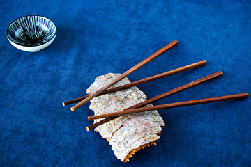 Empty Asian dishware, bowl, pate and chopsticks on the blue background