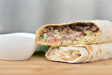 kebab meat with vegetables on a wheat tortilla
