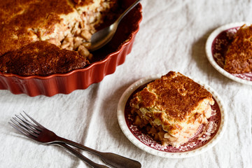Apple and Cheese Cobbler Crisp. Cobbler or Crumble dessert with apples in ceramic baking form on beige linen table. Selective focus