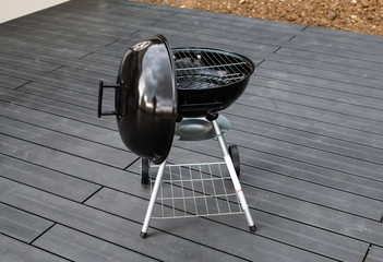 Black barbecue grill isolated on the terrace with composite
