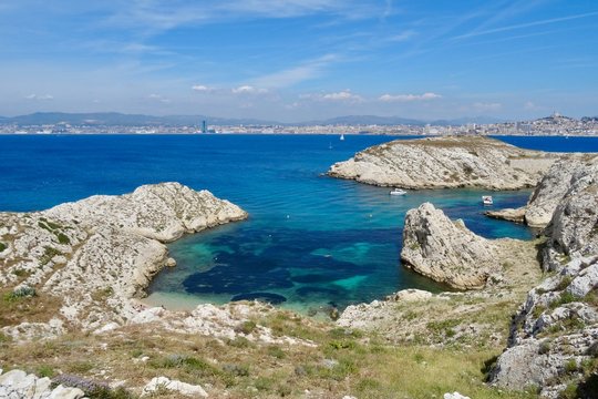 Spectacular view of small bay on the coastline of one of the islands in the Frioul Archipelago in the Mediterranean sea, with the city of Marseille in the background
