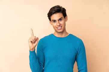 Fototapeta premium Man over isolated background showing and lifting a finger in sign of the best