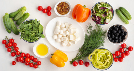 ingredients for summer vegetable salad with feta cheese and mustard on light concrete background.