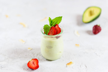 Homemade avocado panna cotta with strawberries and mint in a glass. Sugar, lactose, gluten free. Healthy food, diet, vegetarian.