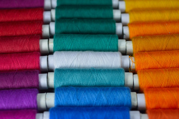 colourful thread rolls arranged in a box